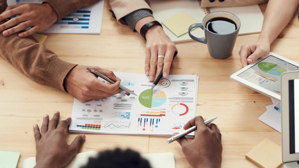 Can AI Really Replace Your Bookkeeper? Here's the Truth Small Business Owners Need Colleagues discussing data and strategy in an office meeting.